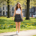 Young woman wearing J Crew pleated mini skirt in sunny setting
